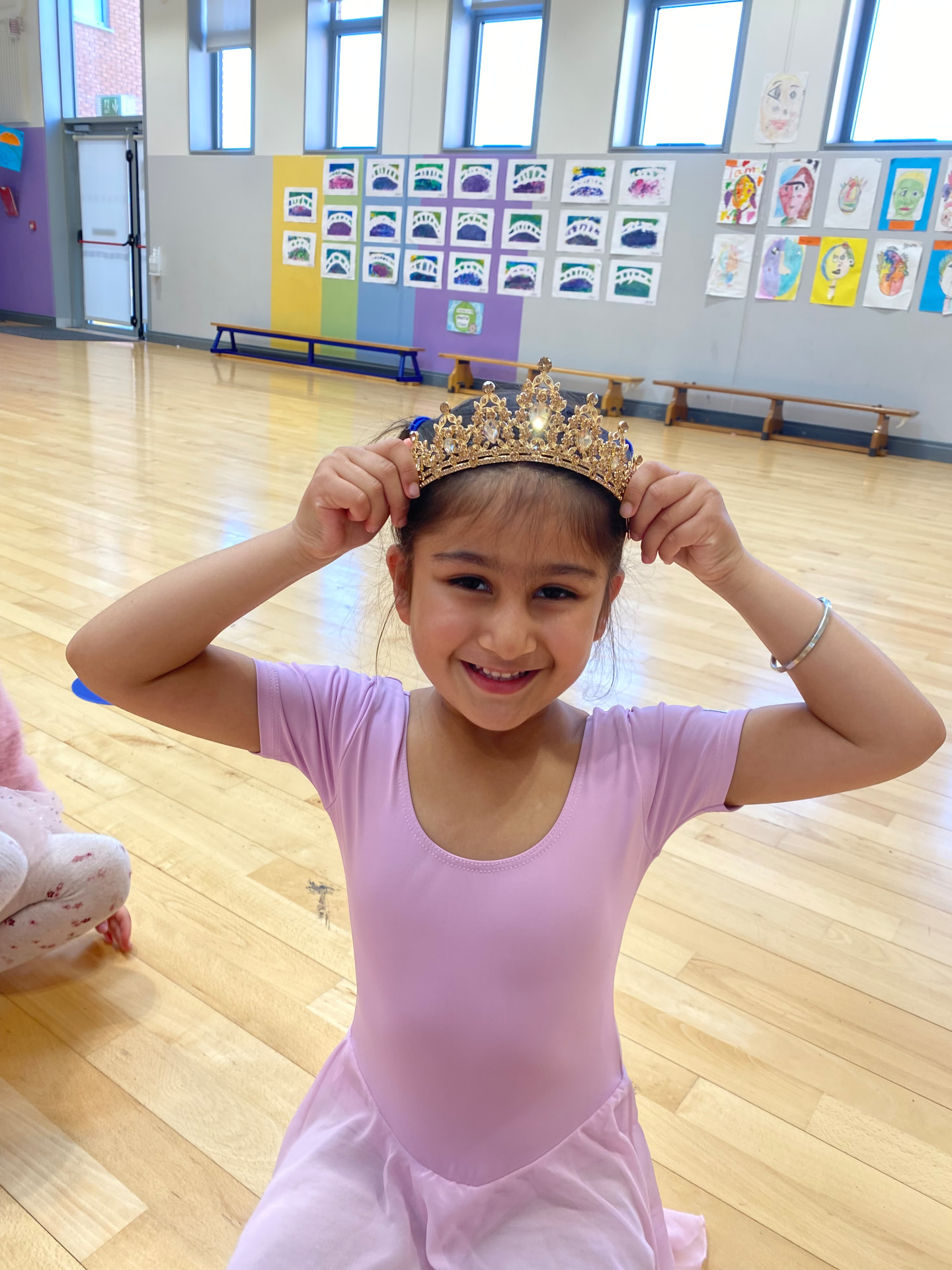 Young dancer adjusting a gold tiara